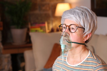 Senior woman using a respirator at home  - obrazy, fototapety, plakaty