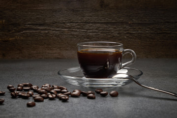 glass Cup of coffee beans with cinnamon and sugar on a dark wooden background