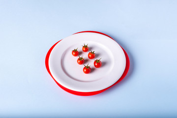 tomates cherry en un plato blanco sobre un fondo azul