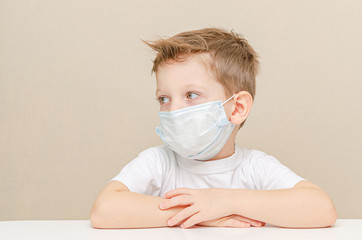 Cute boy of four years in a medical mask. Quarantined children due to an epidemic.