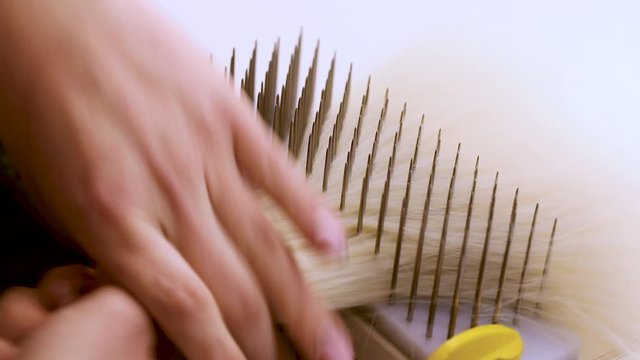Wig Hair Combing. Wig production, female hands close-up.