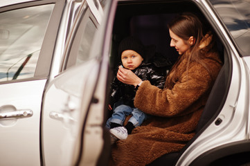 Fototapeta premium Young mother and child in car. Safety driving concept.