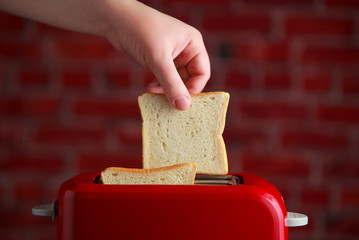 toaster with toasted sliced bread on wooden background. Kitchen equipment