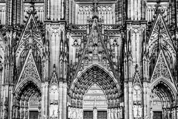 Sculptures and carvings on the facade of the gothic cathedral a UNESCO world heritage site in Cologne, Germany in black and white