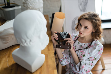 Closeup on attentive beautiful woman visiting art studio and enjoying sculture