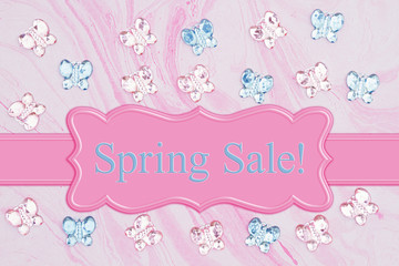 Spring Sale message with pink and blue glass butterflies on pink watercolor paper