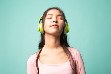 Pretty asian girl listening music with her headphones.