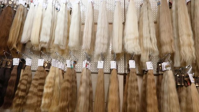 A lot of natural hair for extension on the stand. Fair hair on stand