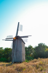Old abandoed ruined ukrainian wooden mill of nineteenth century, summer landscape with forest