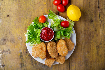 nuggets with ketchup on a plate on a rustic table