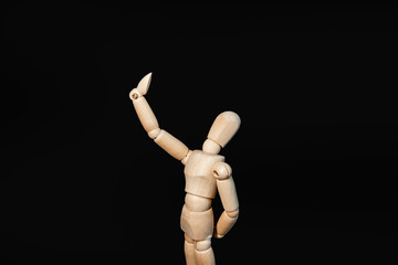the wooden figure raised its hand high, as if looking into a mirror or taking a selfie, proudly admiring itself against a black background
