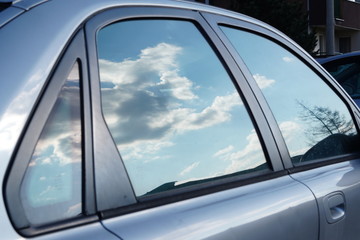 Reflection of the sky and clouds in the window of a car. Blue sky. The clouds