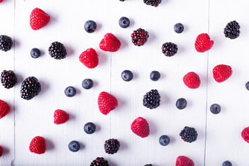 franbuesas, arandanos y moras sobre una mesa rústica blanca