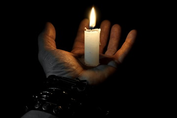 Hand and burning candle.Grief and sadness.Bracelet.