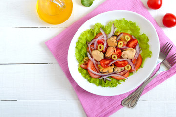 Salad of marinated mussels, fresh tomatoes, red onions, olives in a bowl on a white wooden background. Top view.