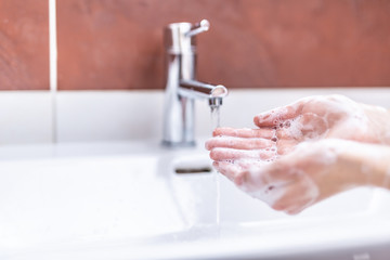 Washing hands with water and liquid soap in the bathroom. Hygiene anti-virus concept