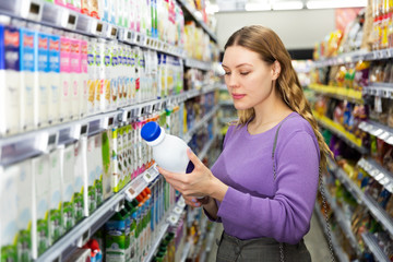 Woman choosing milk in grocery