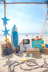 Photo booth setup on beach. Summer, surfing and fishing theme for an event party or birthday.