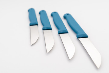 four sharp knives with blue plastic handle on white background