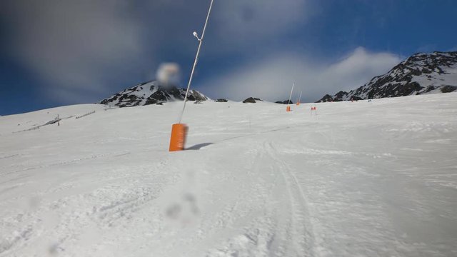 unrecognizable race skier front view following an athlete around a gate corner going very fast down a race slope in France. surrounded by snow, mountains and blue sky