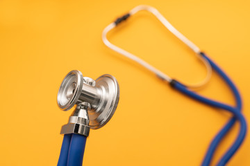Stethoscope on yellow background, top view. Medical instrument