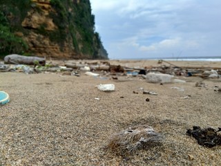 Rubbish in the beach make looks dirty and messy. the pollution because many plastic, wood and others waste.