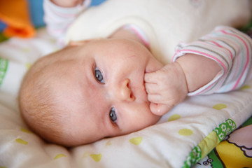 newborn baby licks the hand of the house
