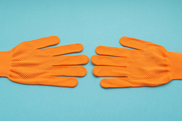 Orange work gloves isolated on blue background
