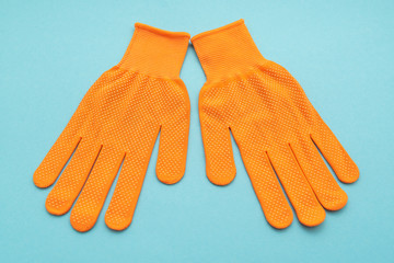 Orange work gloves isolated on blue background