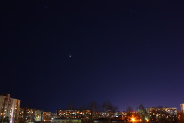 Venus among the stars in the night sky over the city