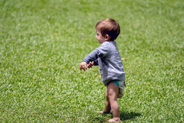 Baby boy playing in the garden of his house