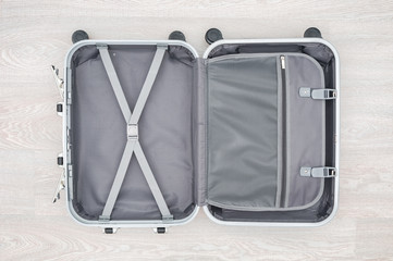 Open travel bag close up on wooden background
