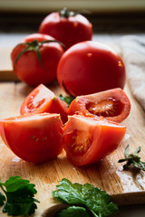 ripe tomatoes on a wooden board with parsley closeup