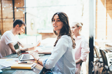 Smiling woman using laptop on meeting with partners
