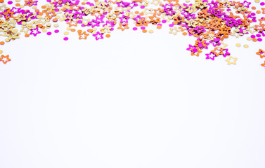 Scattered round confetti and in the form of flowers pink, gold and orange color on a white background. Copy space. Spring and summertime, birthday and wedding concept
