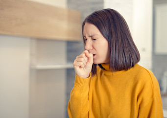 Ill woman with flu virus caughing sneezing indoors at home