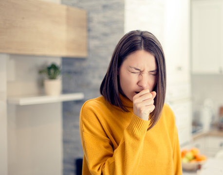 Ill Woman With Flu Virus Caughing Sneezing Indoors At Home