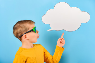 The boy shows on a blank poster for the inscription in the form of a cloud on a blue background.