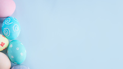 Colorful Easter hunting eggs dyed by colored water with beautiful pattern on pastel blue background, design concept of holiday, top view, copy space.