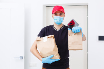 Fototapeta na wymiar Delivery man holding paper bag with food on white background, food delivery man in protective mask