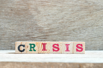 Alphabet letter in word crisis on wood background