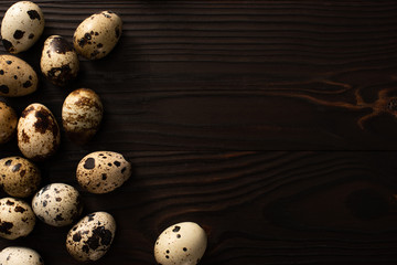 top view of quail eggs on brown wooden surface