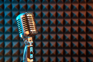 Retro microphone on acoustic foam panel background, - obrazy, fototapety, plakaty