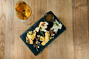 Antipasto - a cheese plate. Different, homemade cheeses on a ceramic plate - brie, camembert, Dutch with honey and nuts. Wine appetizer. Top view