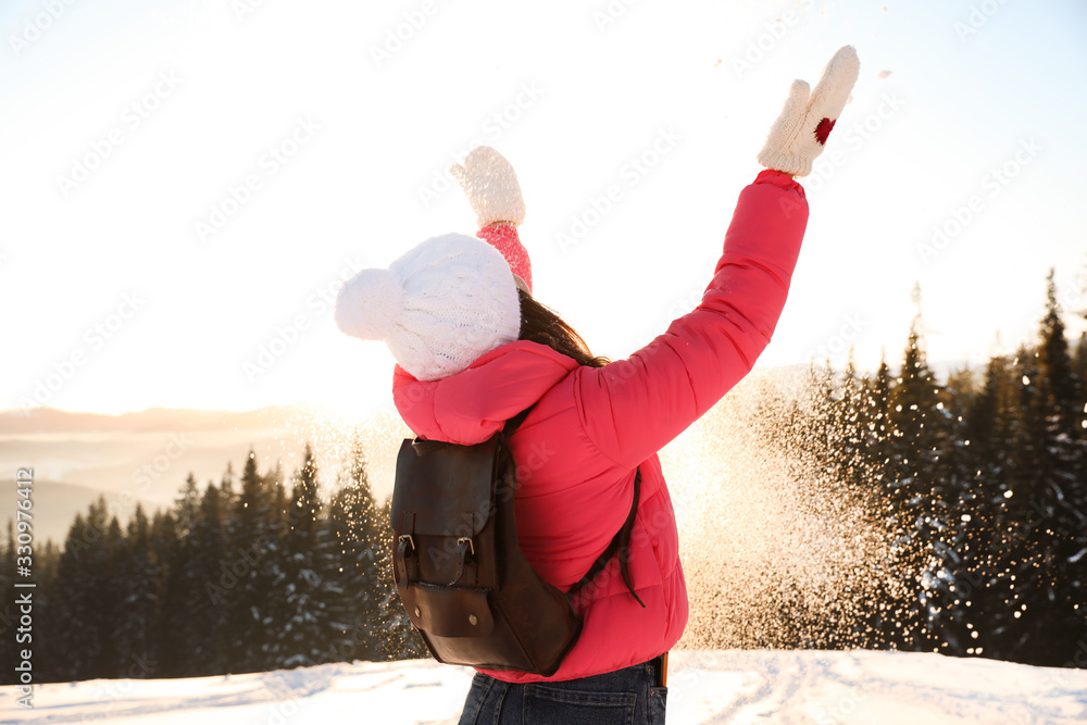 Wall mural Young woman having fun outdoors on snowy winter day