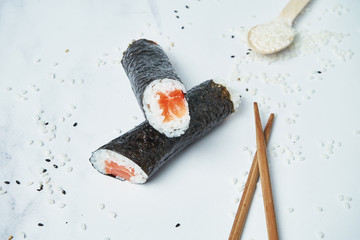 Fresh rolls with fresh salmon, rice and norms on a white background. Japanese traditional sushi rolls. Close up, selective focus