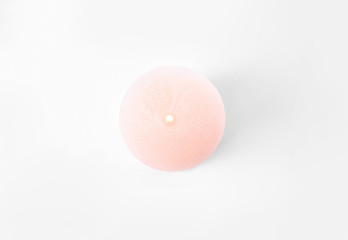Burning pink candle isolated on white, top view