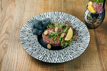 Fresh beef tartar with capers, sawn egg yolk and parmesan cheese. Delicious appetizer. Close up view