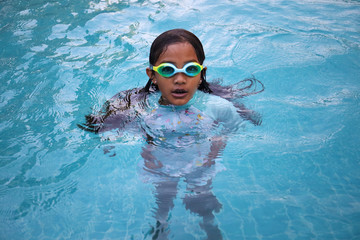 An asian girl wears google in the pool