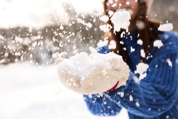 Young woman playing with snow outdoors, closeup. Winter vacation